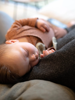 Baby sleeping in mum's arms