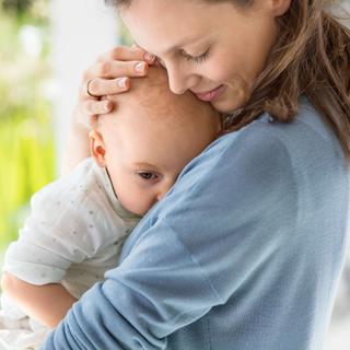 Mutter hält ihr Baby liebevoll im Arm und kuschelt es beim behutsamen Abschied vom Stillen