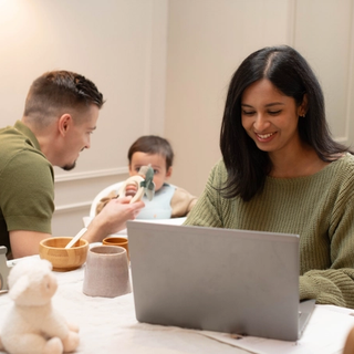 Mum working for home whilst dad feeds baby