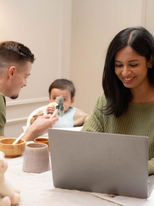 Mum working for home whilst dad feeds baby