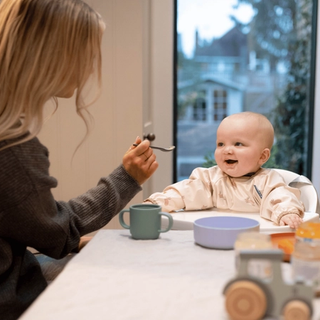 Mum spoon feeding baby