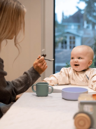 Mum spoon feeding baby