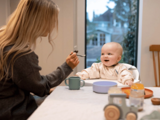 Mum spoon feeding baby