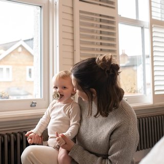 Mum and baby laughing together whilst getting ready