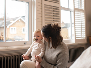 Mum and baby laughing together whilst getting ready
