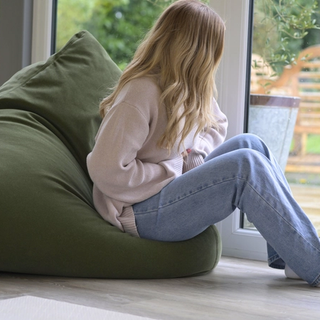 Woman holding stomach whilst looking out of window