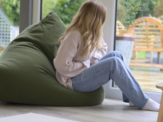 Woman holding stomach whilst looking out of window