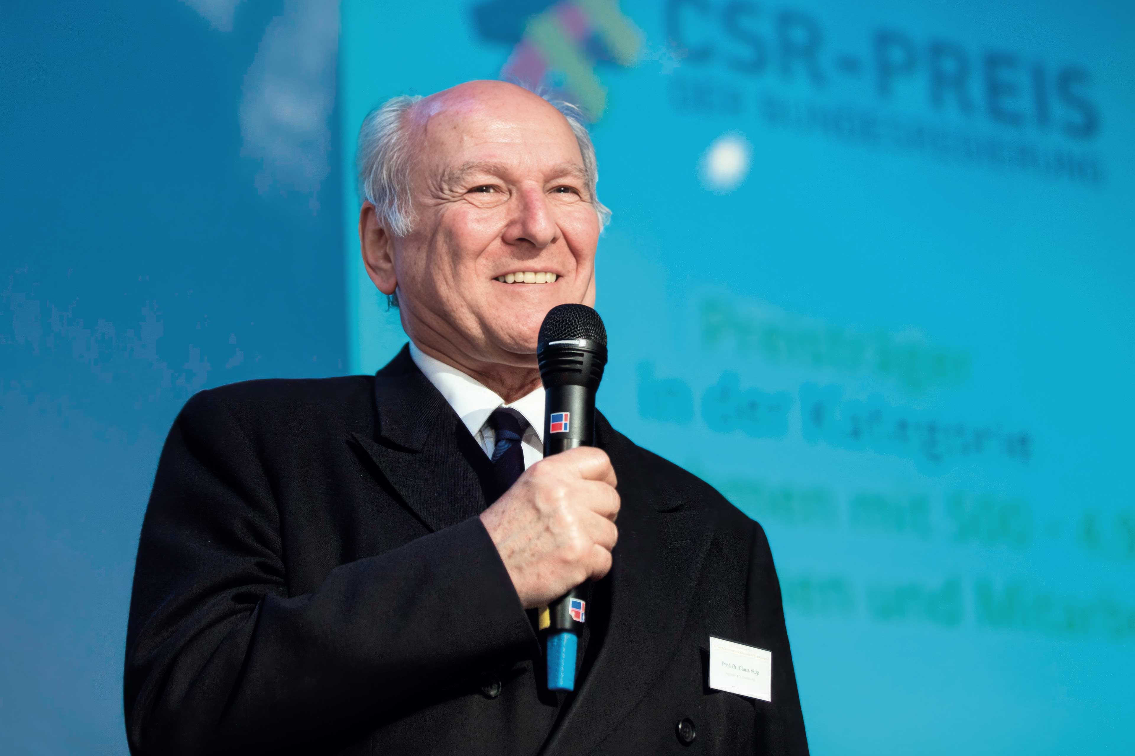 Claus Hipp mit Mikrophon in der Hand beim CSR-Preis