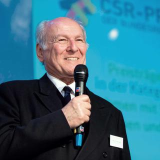 Claus Hipp mit Mikrophon in der Hand beim CSR-Preis