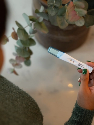 Expecting mum holding up positive pregnancy test