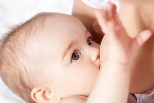 Nahaufnahme eines Babygesichts mit Schwerpunkt auf den Augen und dem Akt des Stillens.