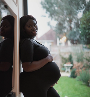 Pregnant mum posing for a photo whilst holding her bump