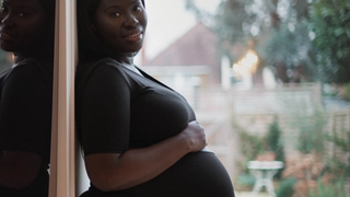 Pregnant mum posing for a photo whilst holding her bump