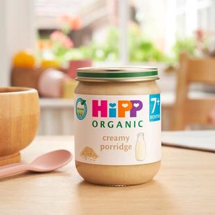 HiPP Organic Creamy Porridge on a dining table next to a bowl and spoon