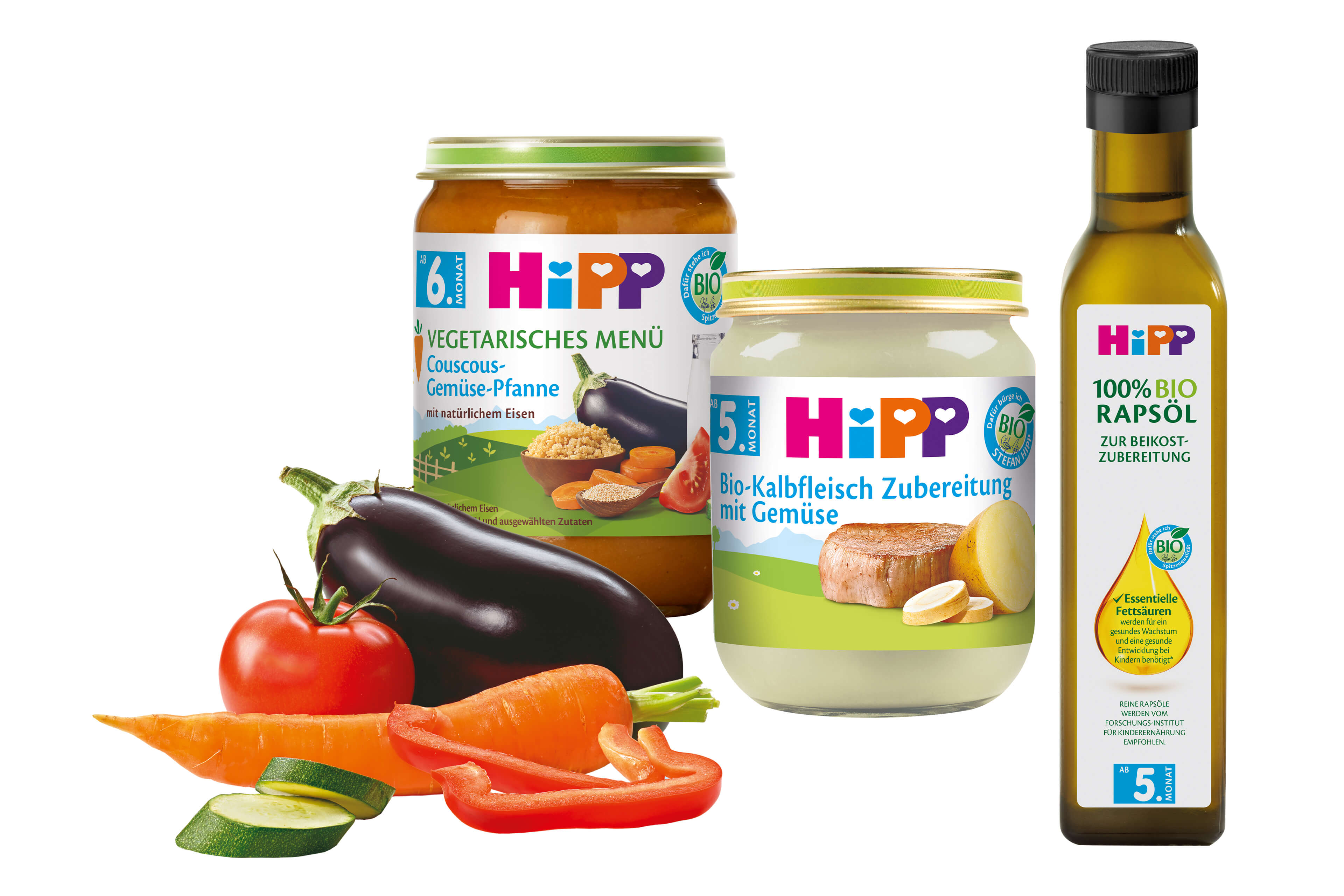 Eine Reihe von Babynahrungsprodukten der Marke "Hipp", begleitet von frischem Gemüse wie Tomaten, Karotten und Gurken.