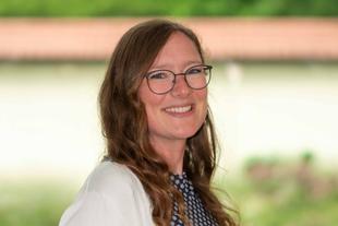 Verena, freundlich lächelnde Ernährungswissenschaftlerin im HiPP Muttermilchforschungsteam, Porträt vor unscharfem Hintergrund