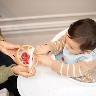 Mum feeding baby a healthy pudding