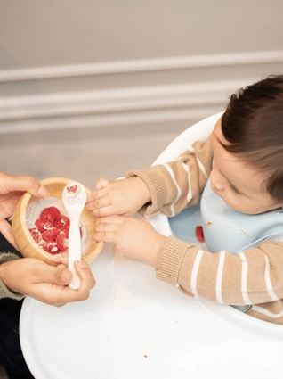 Mum feeding baby a healthy pudding
