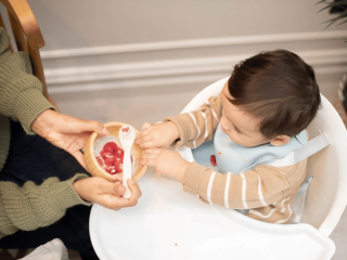 Mum feeding baby a healthy pudding