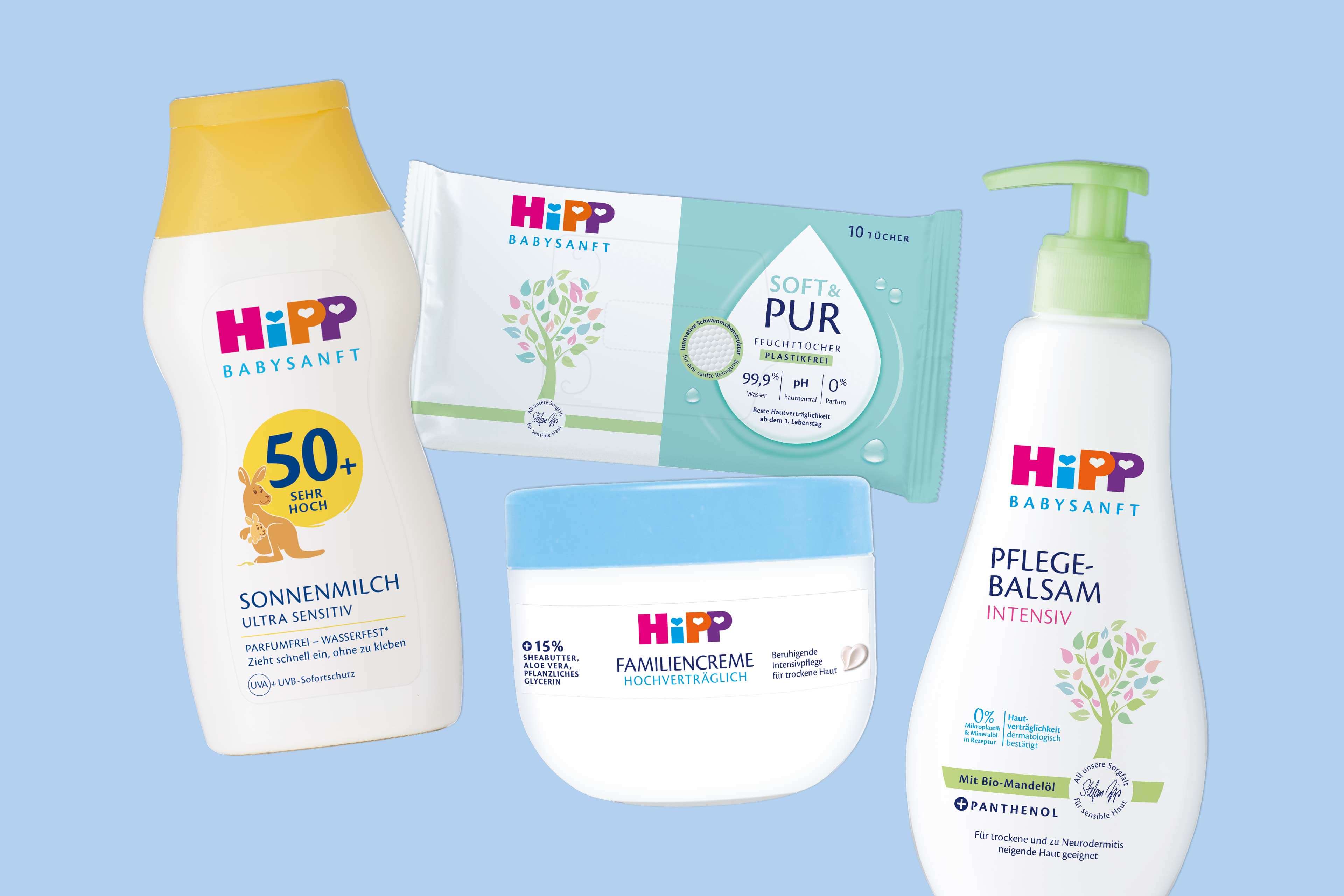 Vier HiPP Babysanft Pflegeprodukte auf hellblauem Hintergrund bestehend aus Sonnenmilch, Feuchttüchern, Familiencreme und Pflegebalsam mit Pumpspender