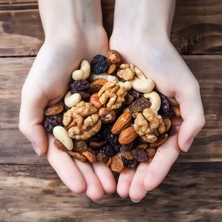 Eine Vielzahl von Nüssen, darunter Mandeln, Walnüsse und Cashews, die auf einem Haufen angeordnet sind.