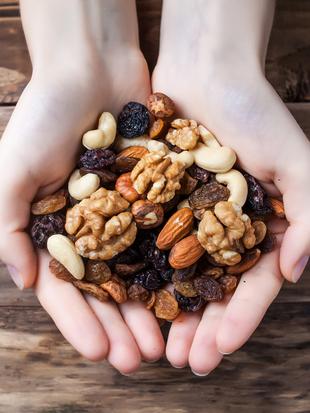 Eine Vielzahl von Nüssen, darunter Mandeln, Walnüsse und Cashews, die auf einem Haufen angeordnet sind.
