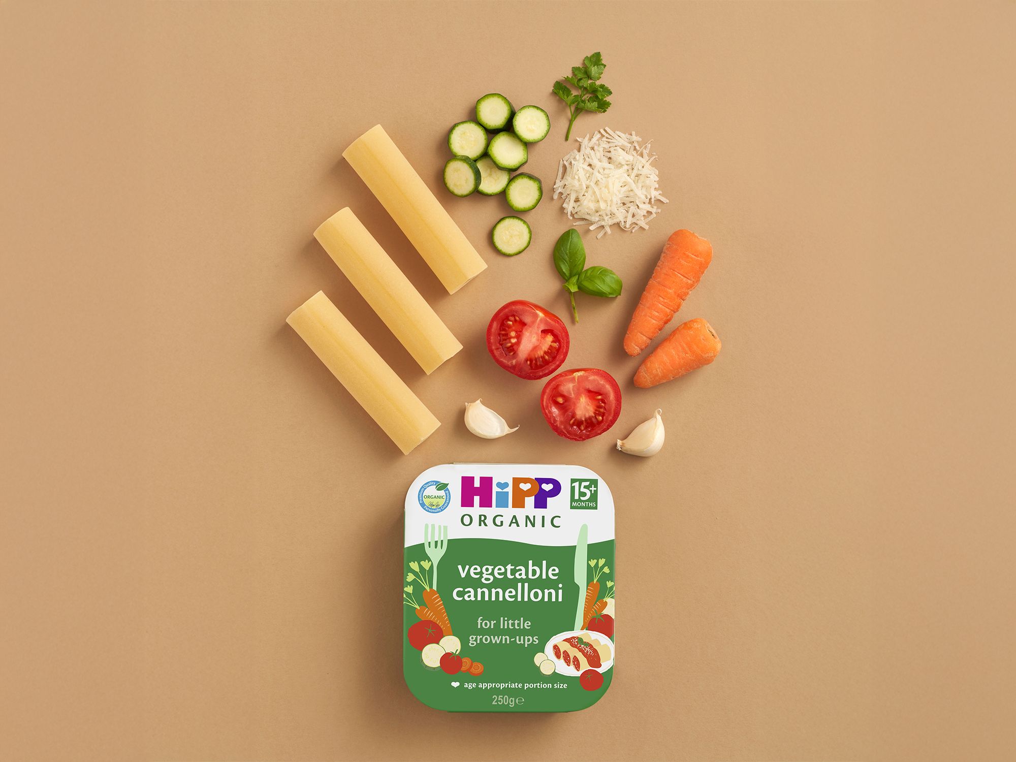 HiPP Organic Vegetable Cannelloni tray with pasta tubes and fresh vegetables arranged on a neutral background