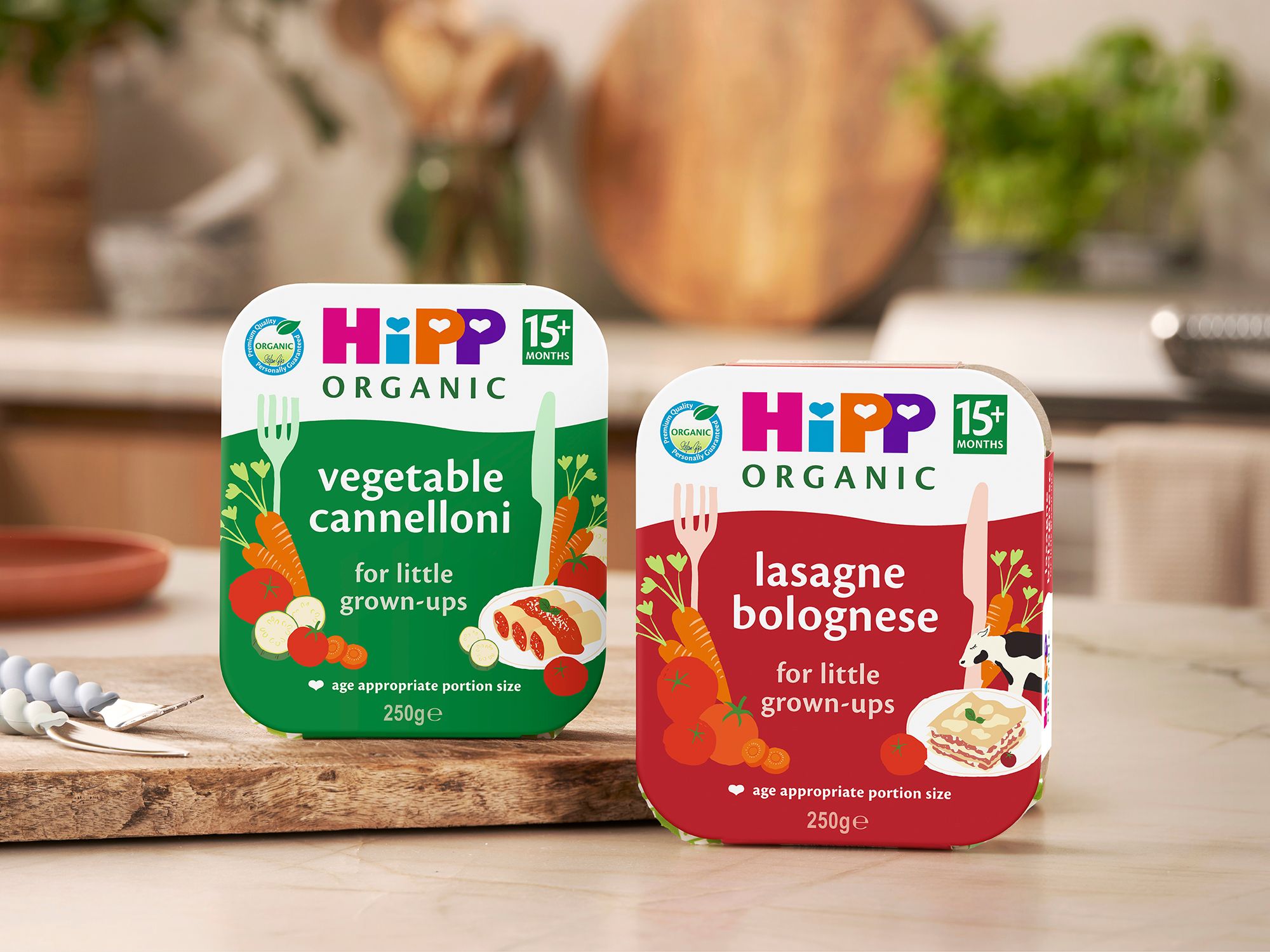 HiPP Organic Vegetable Cannelloni and Lasagne Bolognese tray meals for 15+ months displayed on a cosy kitchen worktop