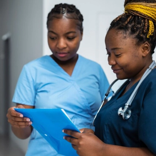 Midwives conferring over a patatient chart
