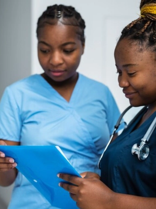 Midwives conferring over a patatient chart