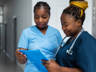 Midwives conferring over a patatient chart