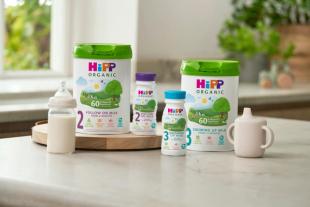 HiPP follow on and growing up milks next to milk bottle and beaker