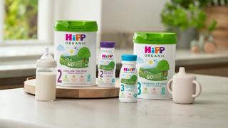 HiPP follow on and growing up milks next to milk bottle and beaker