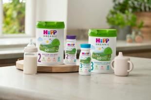HiPP follow on and growing up milks next to milk bottle and beaker