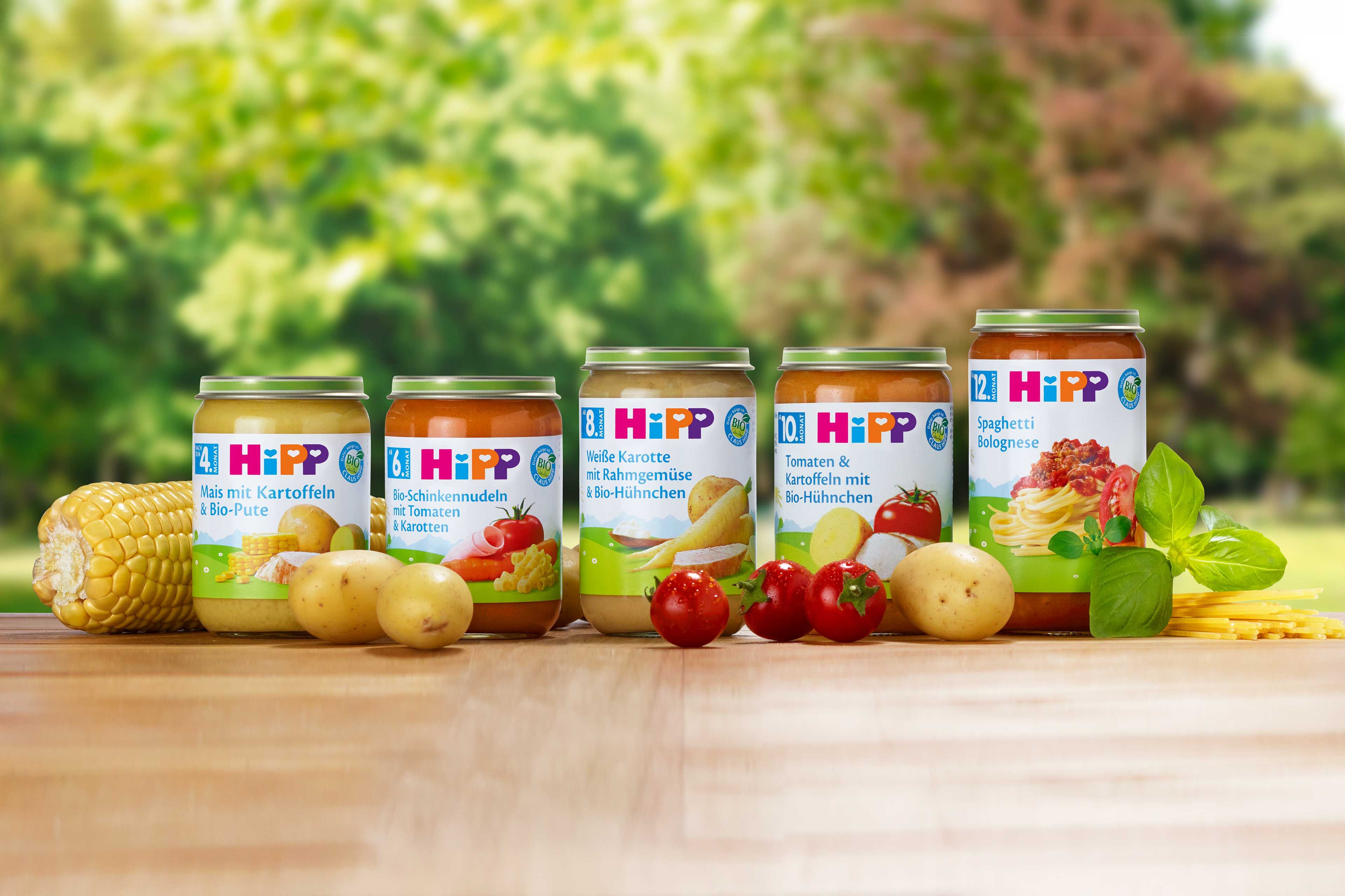 Mehrere HiPP Babyglääschen nebeneinander, rund herum Obst und Gemüse