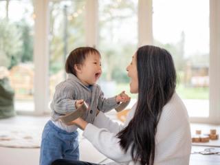 Mum and toddler laughing together