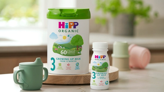 HiPP organic growing up milk powder and ready to fee with green beaker on ktichen side