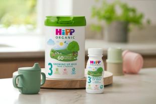 HiPP organic growing up milk powder and ready to fee with green beaker on ktichen side