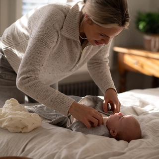 Mum swaddling baby