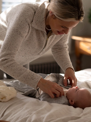 Mum swaddling baby