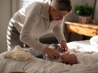 Mum swaddling baby