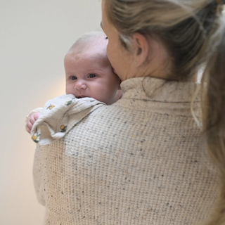 Newborn baby looking over mum's shoulder