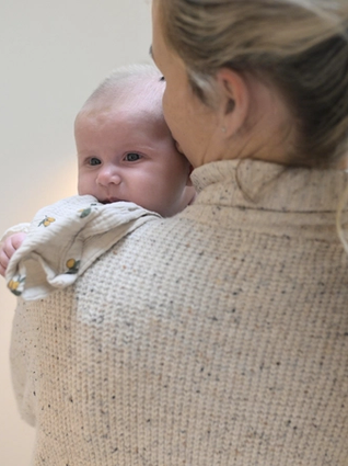 Newborn baby looking over mum's shoulder