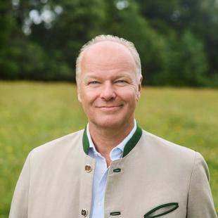 Portrait von Stefan HiPP mit Wiese und Wald im Hintergrund