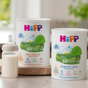 HiPP Organic comfort milk and anti‑reflux tins on a kitchen worktop beside a prepared baby bottle of formula