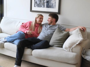Man and woman sitting on a sofa looking at each other