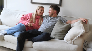 Man and woman sitting on a sofa looking at each other
