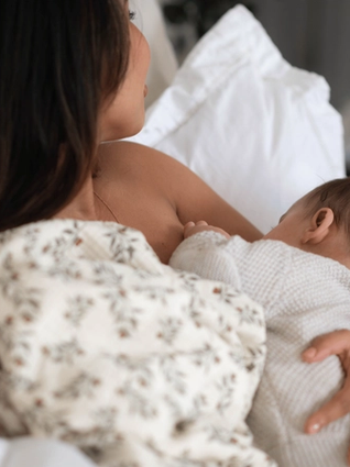 Mum breastfeeding baby in bed