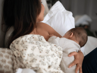 Mum breastfeeding baby in bed