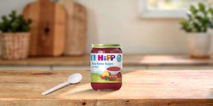 HiPP Bio Babyglas „Rote Beete Suppe mit Rind“ auf Holztisch mit Löffel in heller, gemütlicher Küche